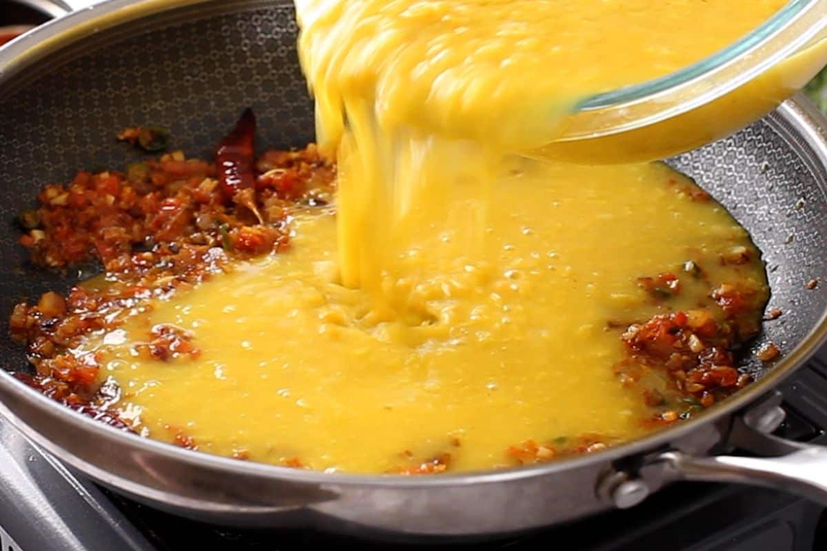 Cooked lentils are added to the tadka.