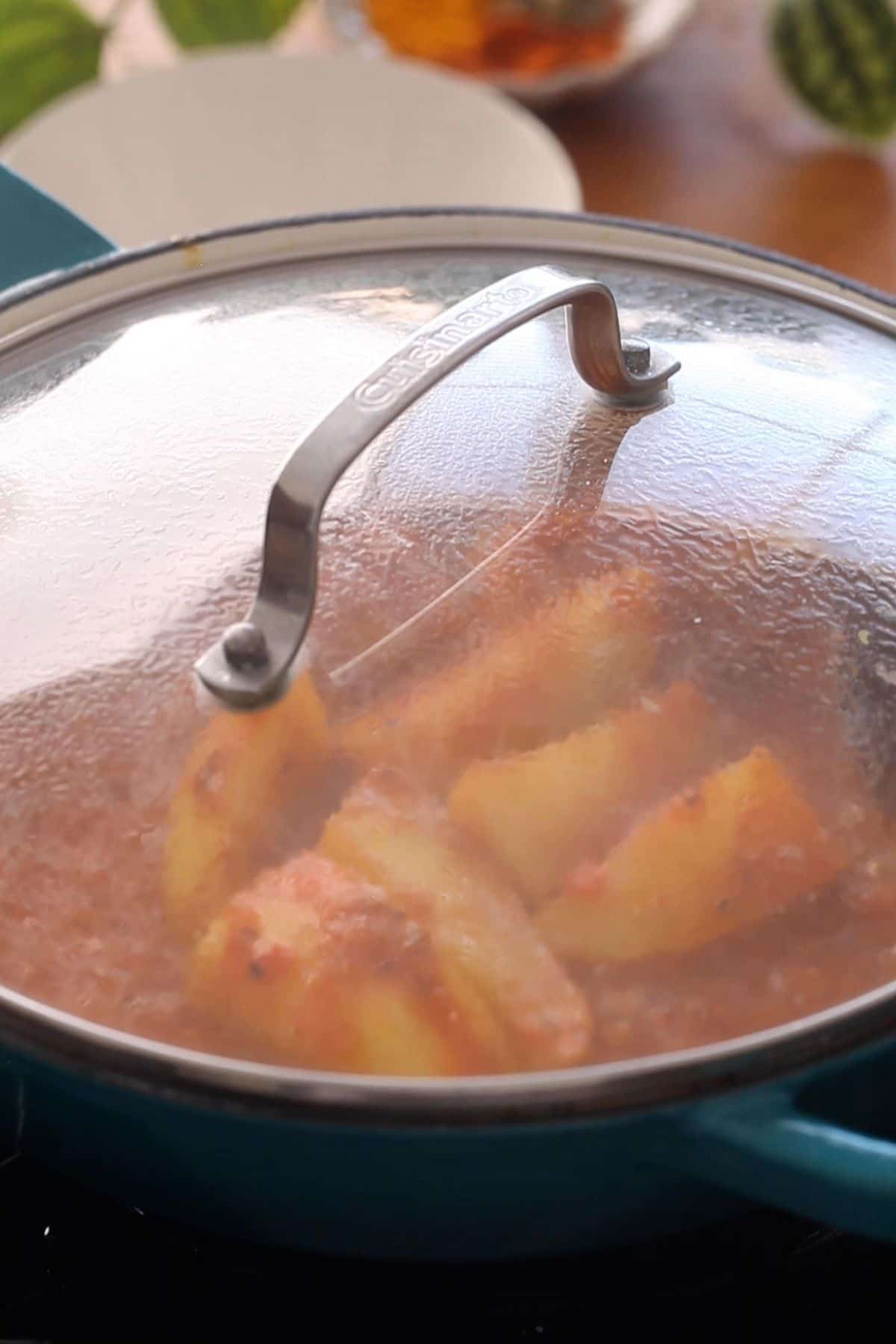 Cooking pot is covered to let potatoes par cook.