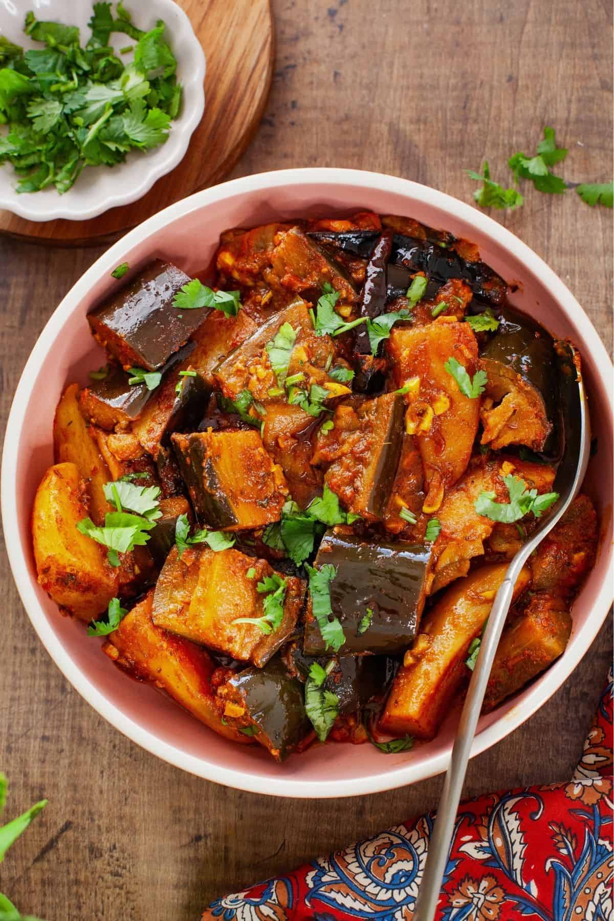 Punjabi Aloo baingan served in a pink bowl.