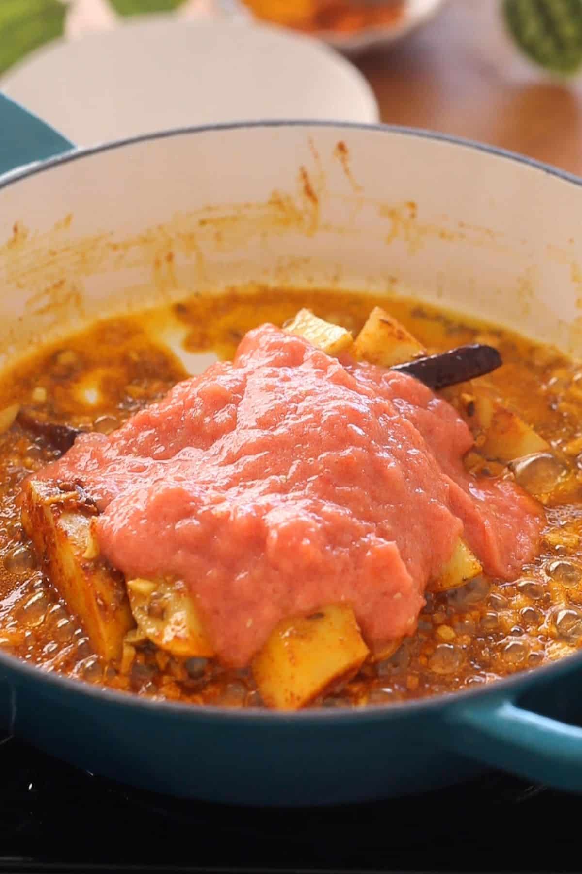 Tomato puree added to potatoes.