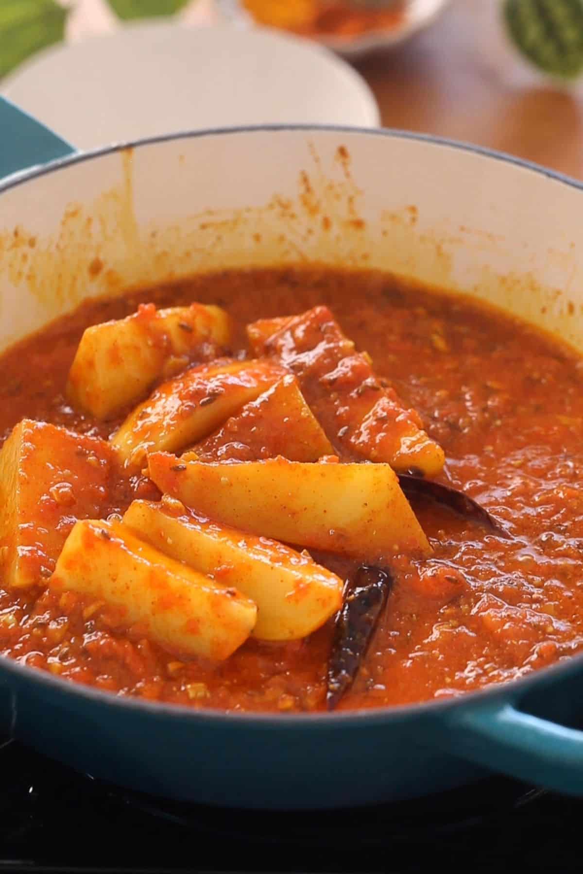 Potatoes frying with tomatoes.
