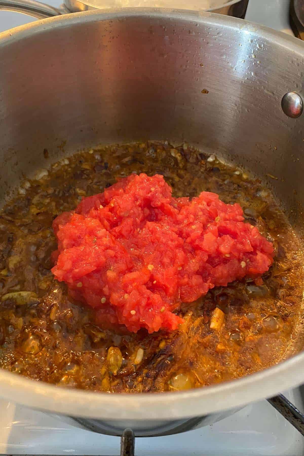 Add crushed tomatoes to the pot.