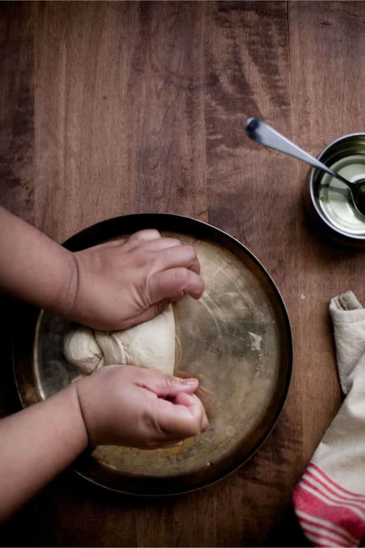 Kneading the roti dough with both hands to make it ultra soft and smooth.