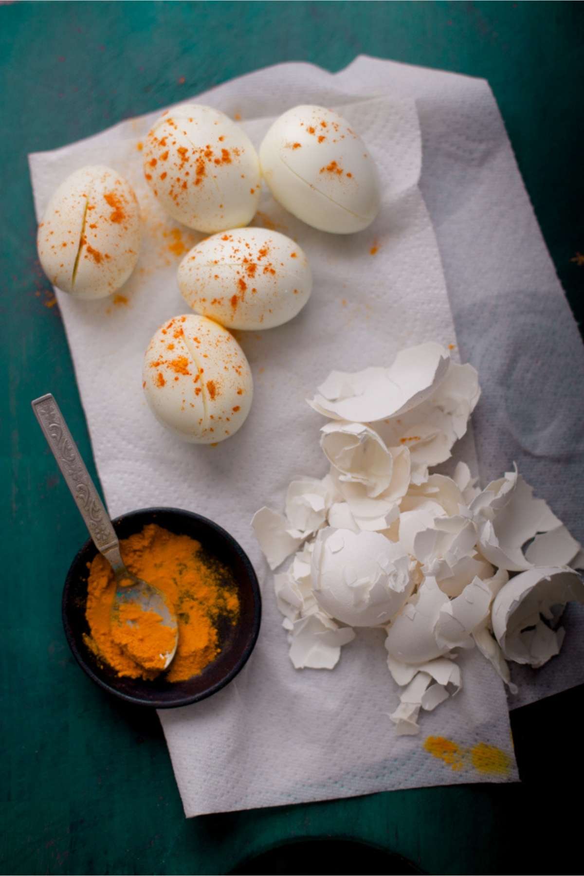 Peeled hardboiled eggs sprinkled with turmeric powder.