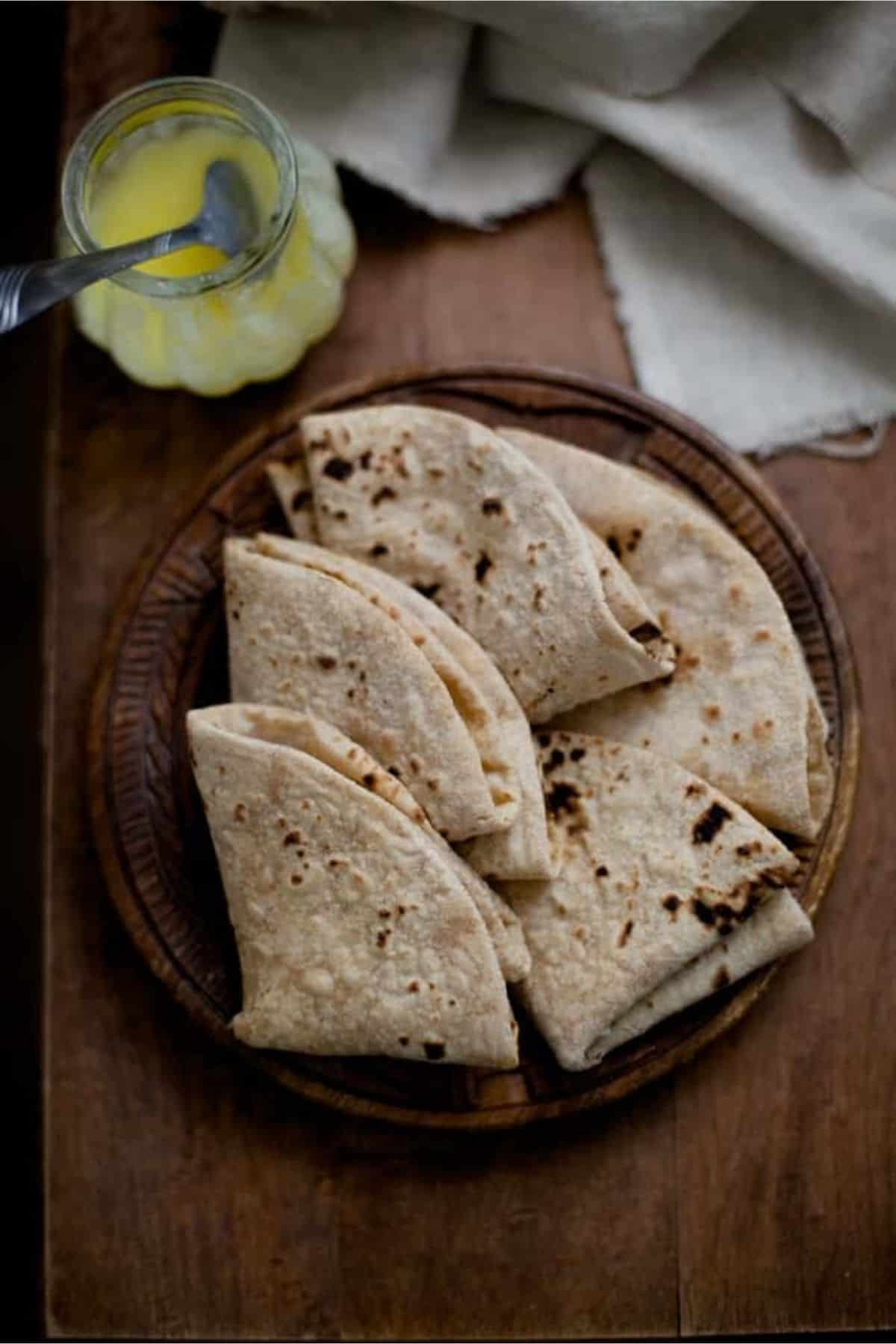 Rotis folded in small triangles and placed on wooden plate.