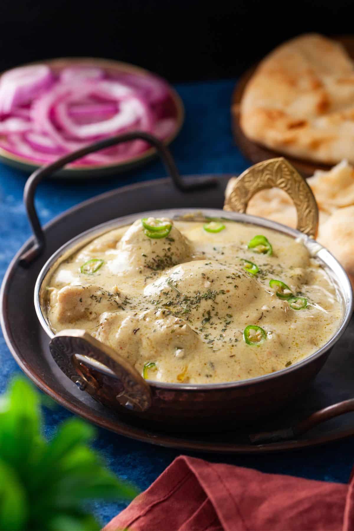 Murgh korma served in a small wok shaped dish.