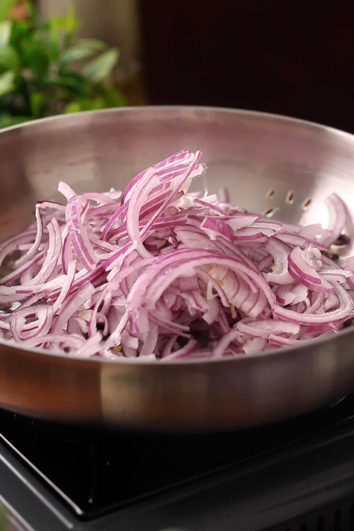 Sliced onions is added to hot oil.