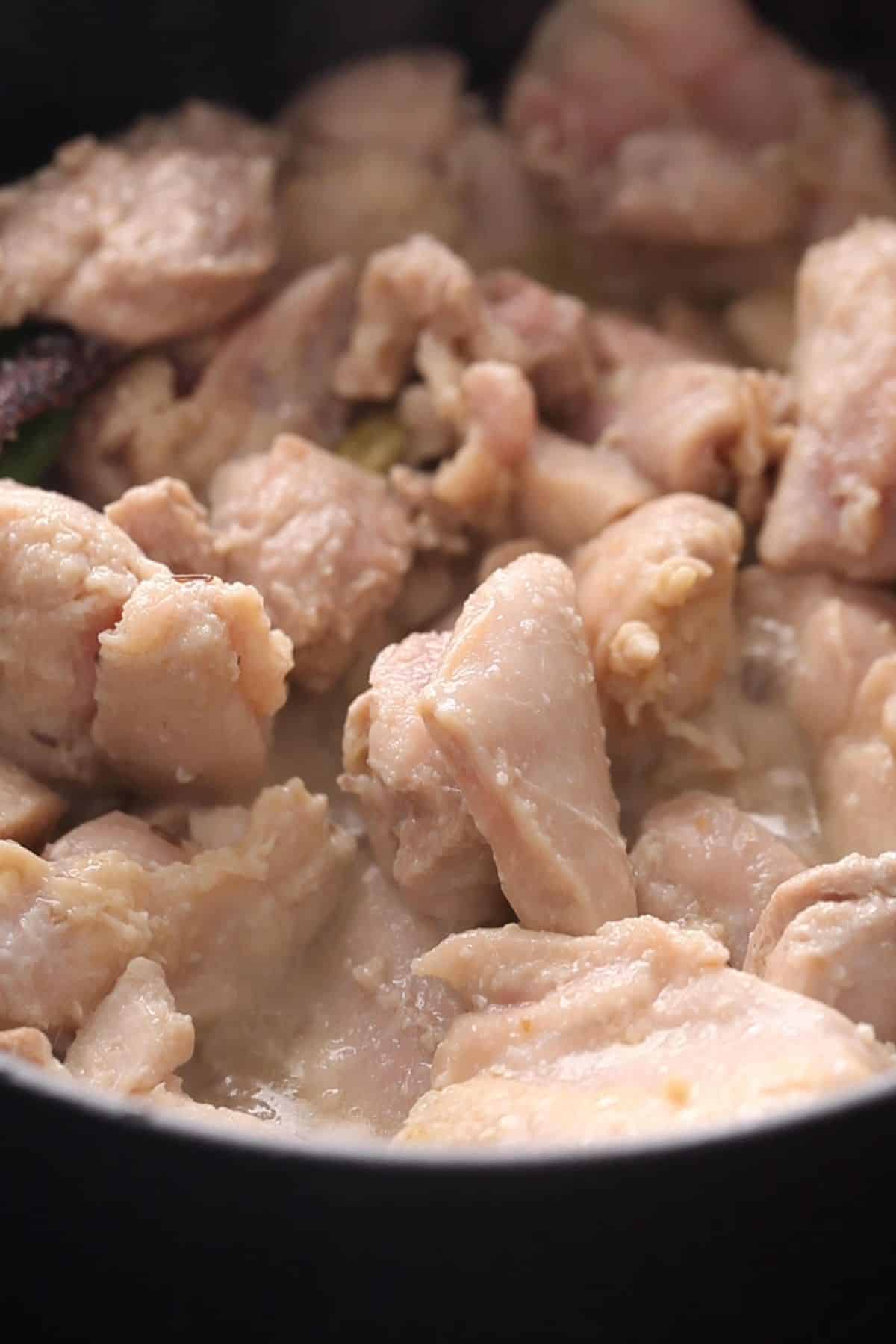 The chicken is lightly seared and is no longer pink. 