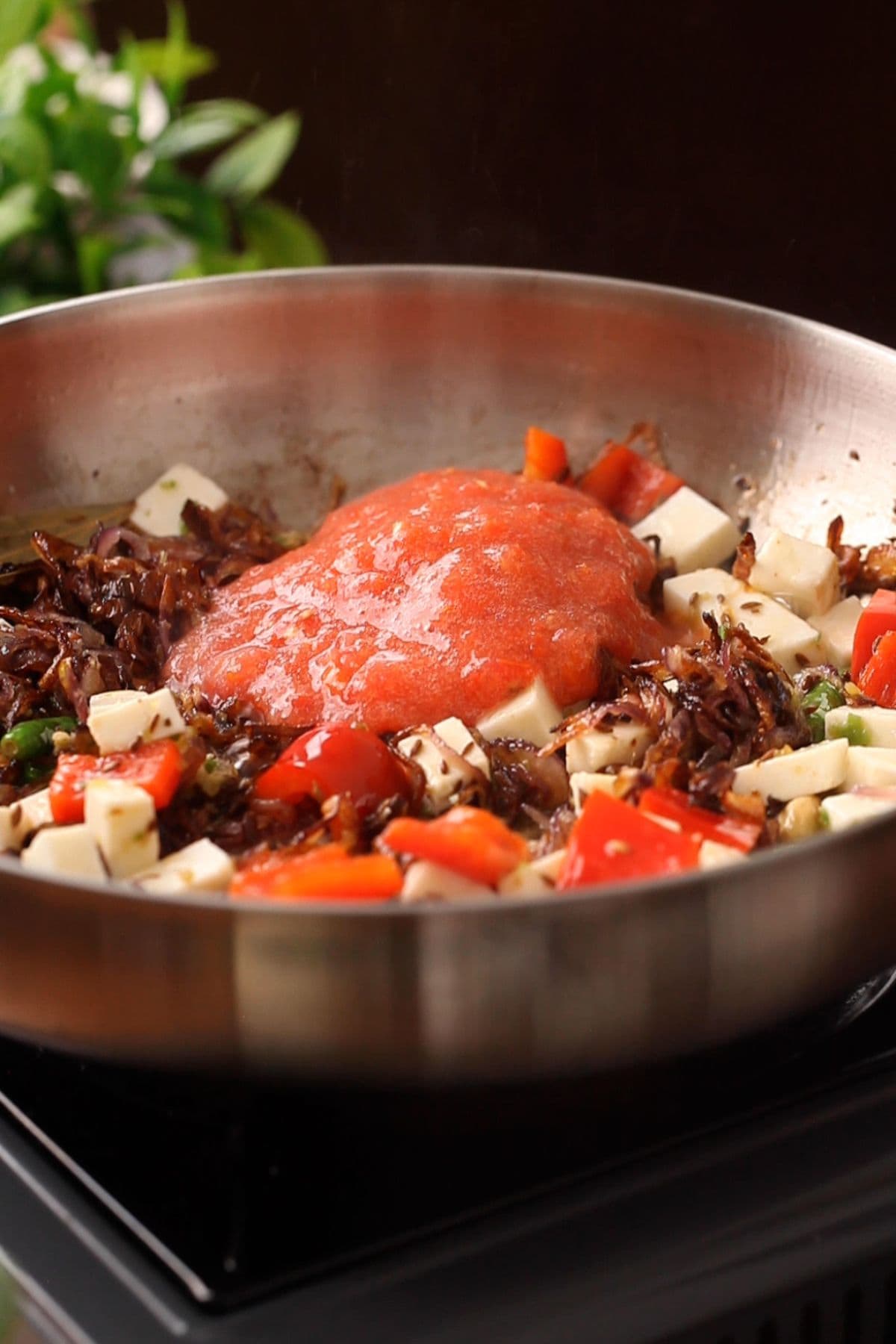 Crushed tomatoes are added to the skillet. 
