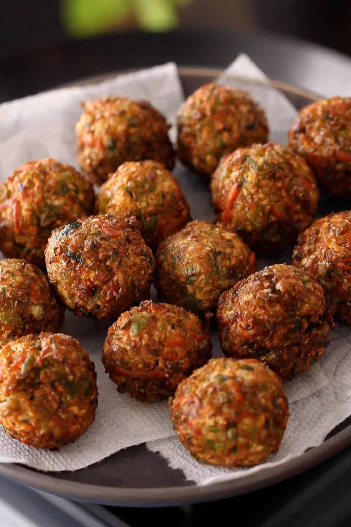 Deep fried vegetable dumplings on a white paper towel.