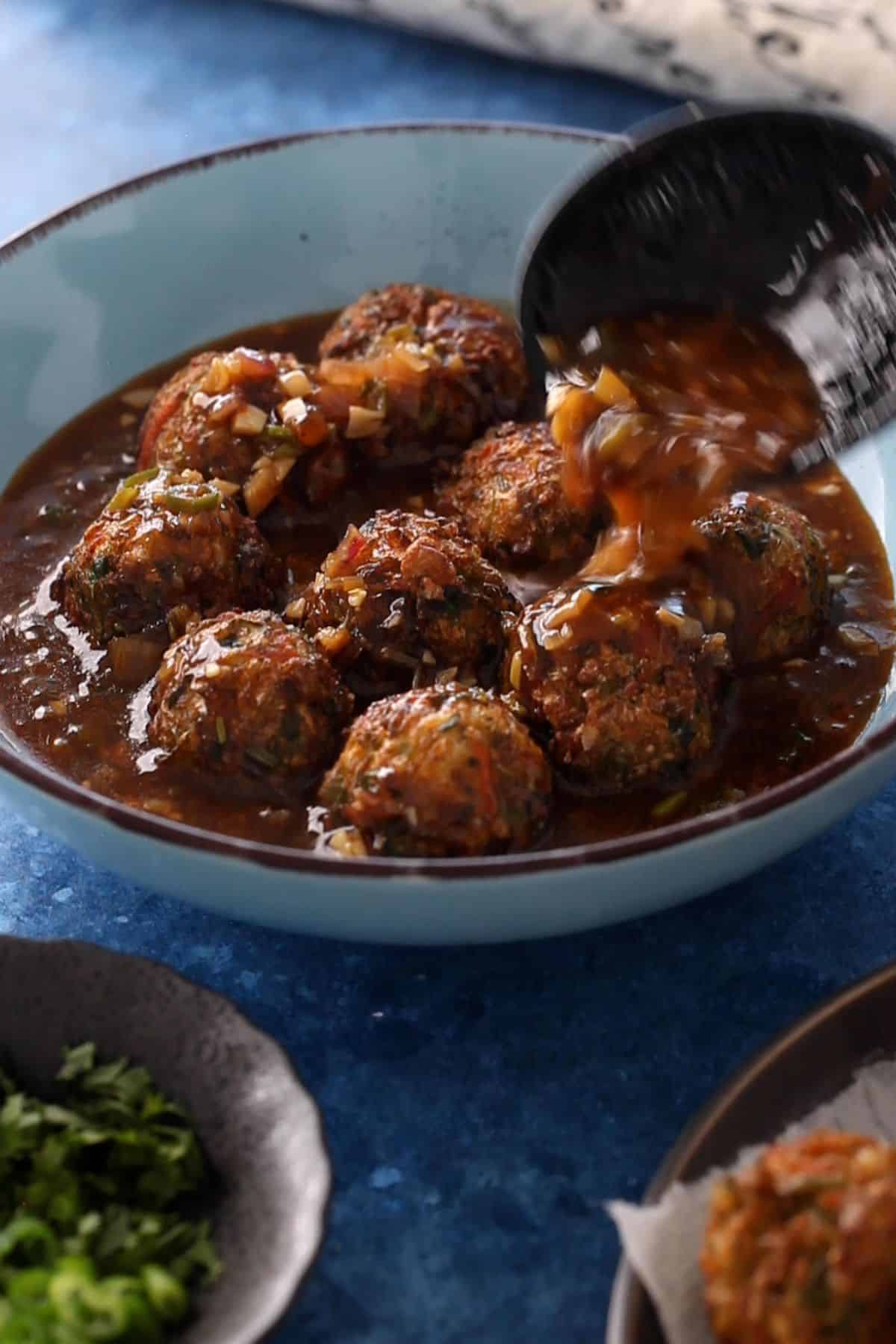 Vegetable manchurian is assembled in a rustic blue bowl.