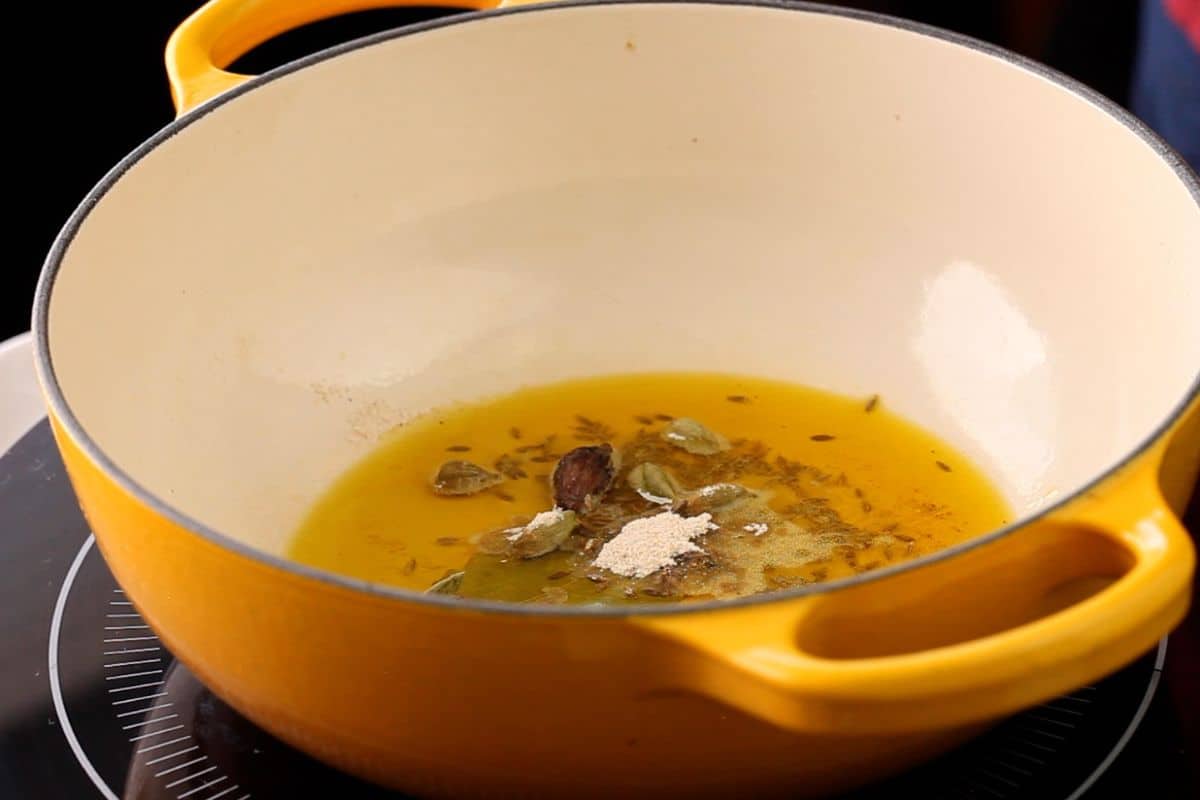 Whole spices are added to hot mustard oil.