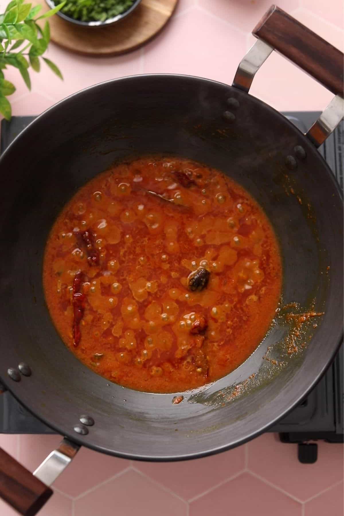 Tomatoes are cooked until ghee bubbles appear.