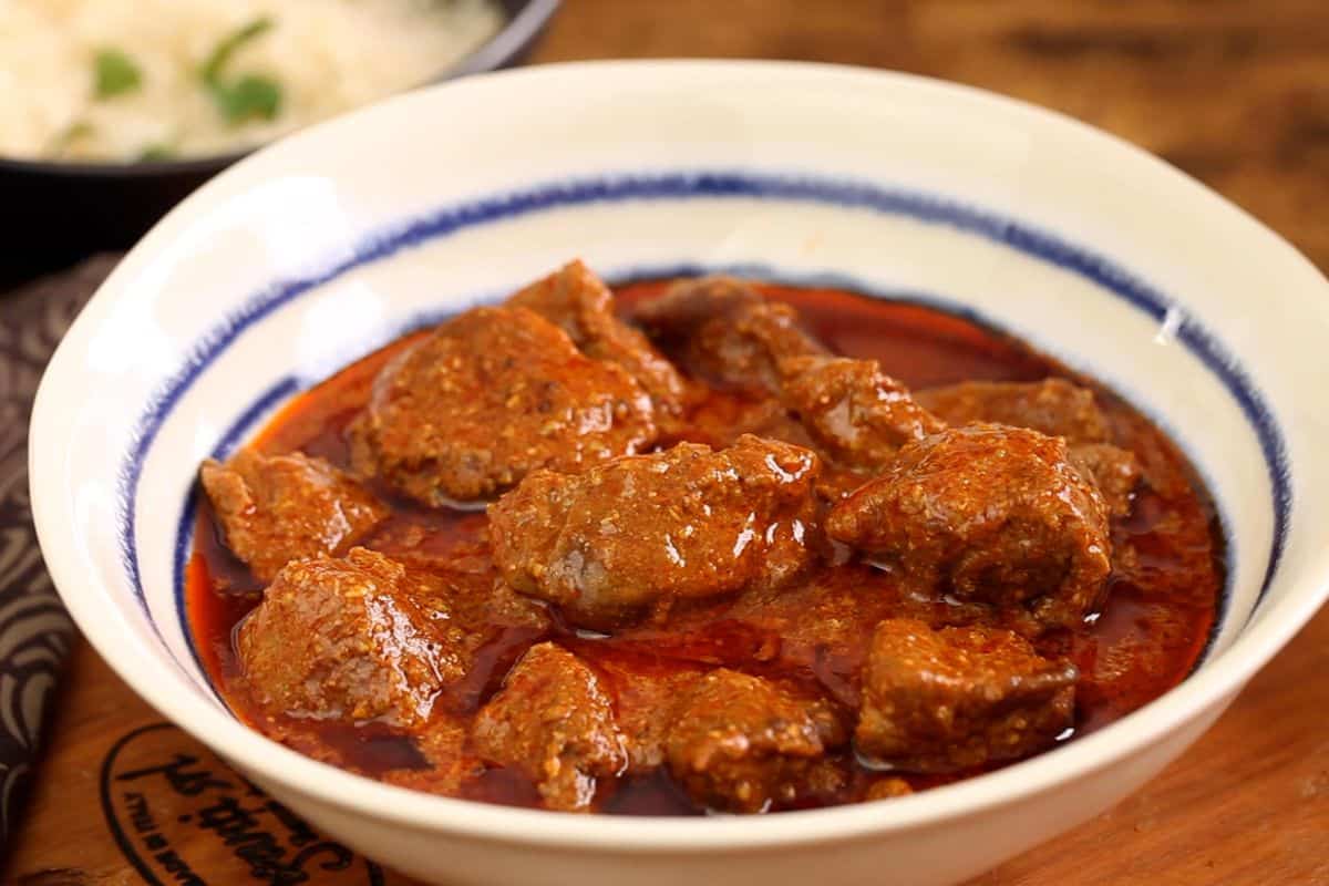 Lamb rogan josh is plated in a white bowl.