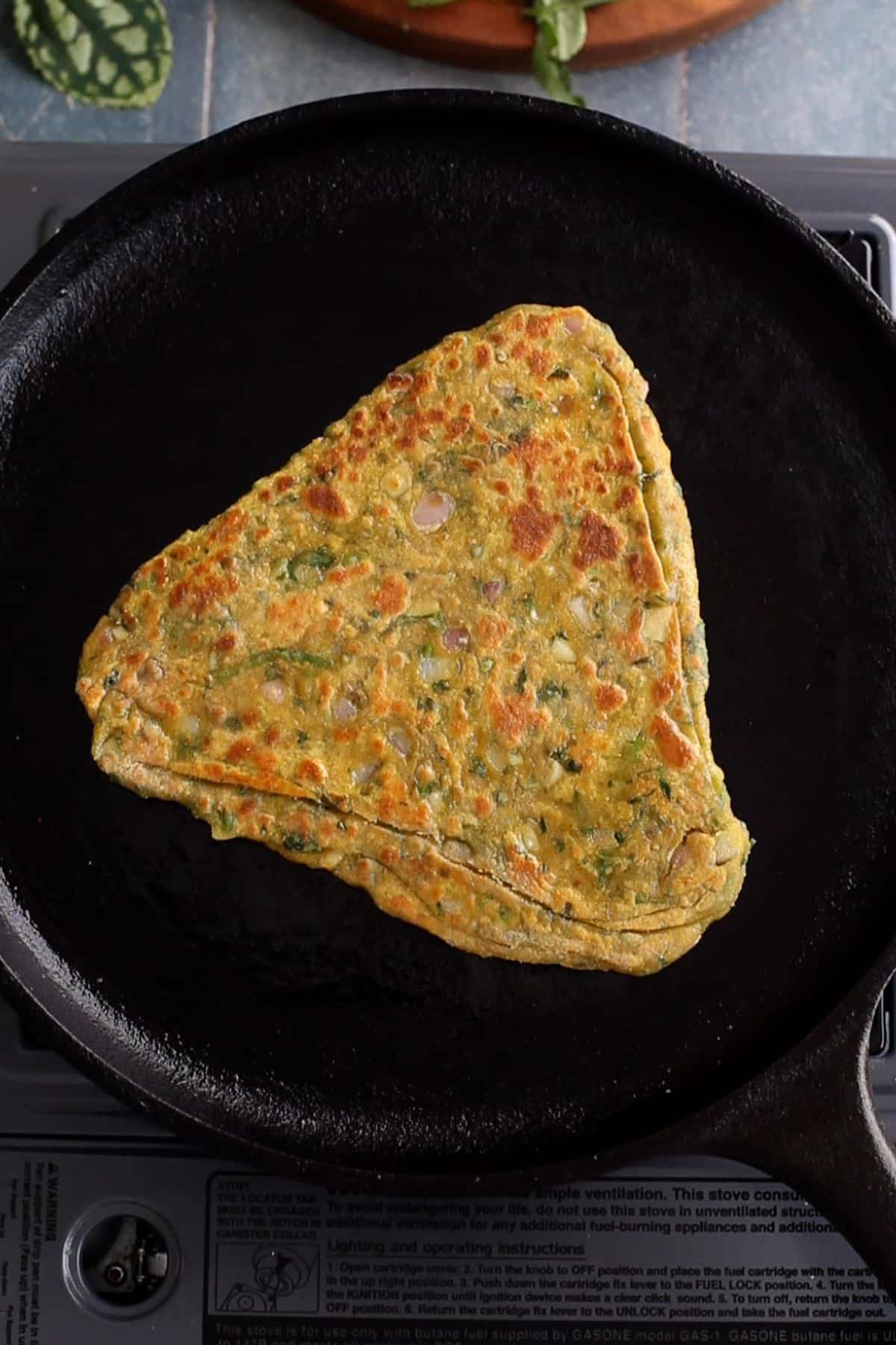 Methi paratha is cooked with golden spots.