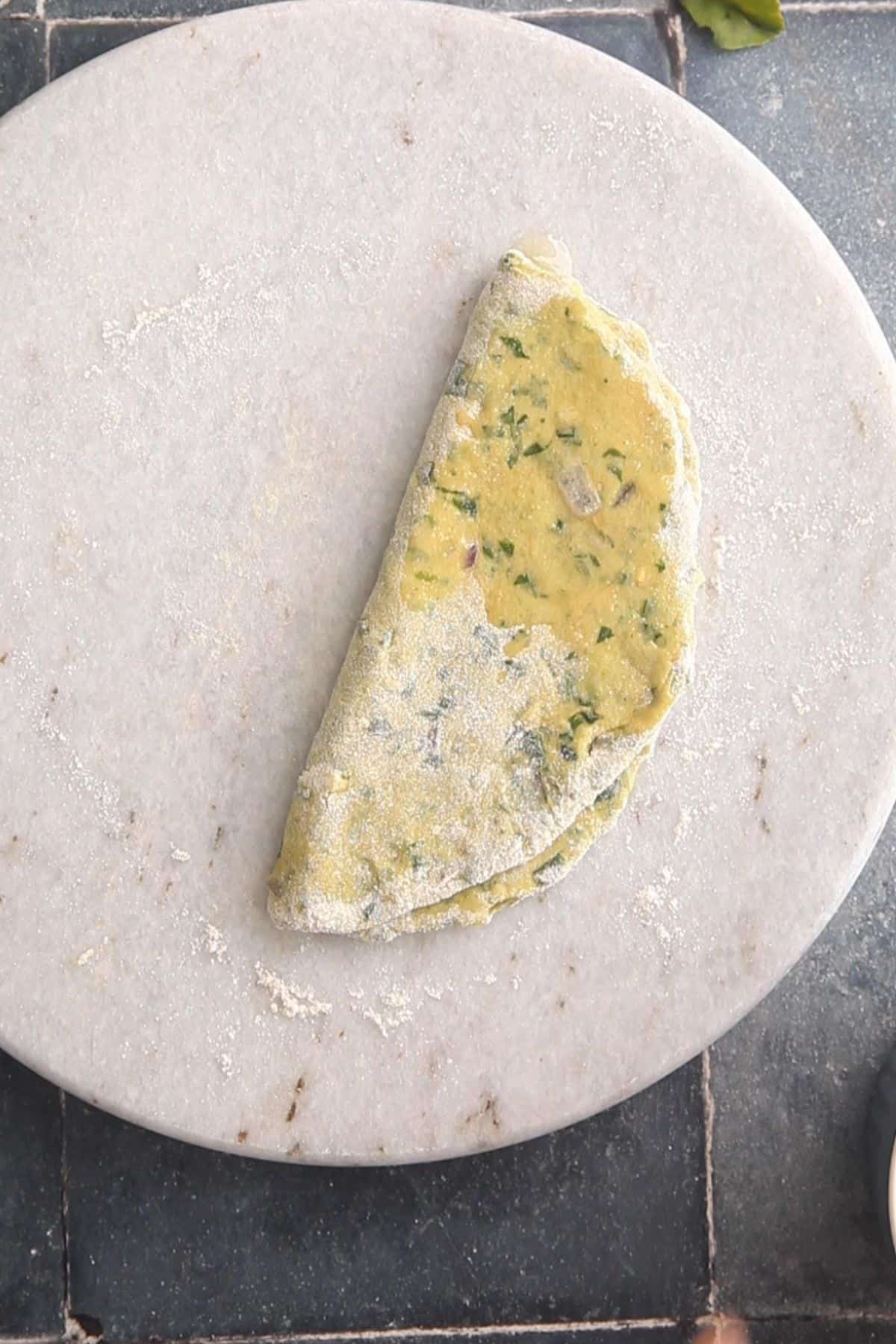 Rolled dough is folded over to make a semi circle.