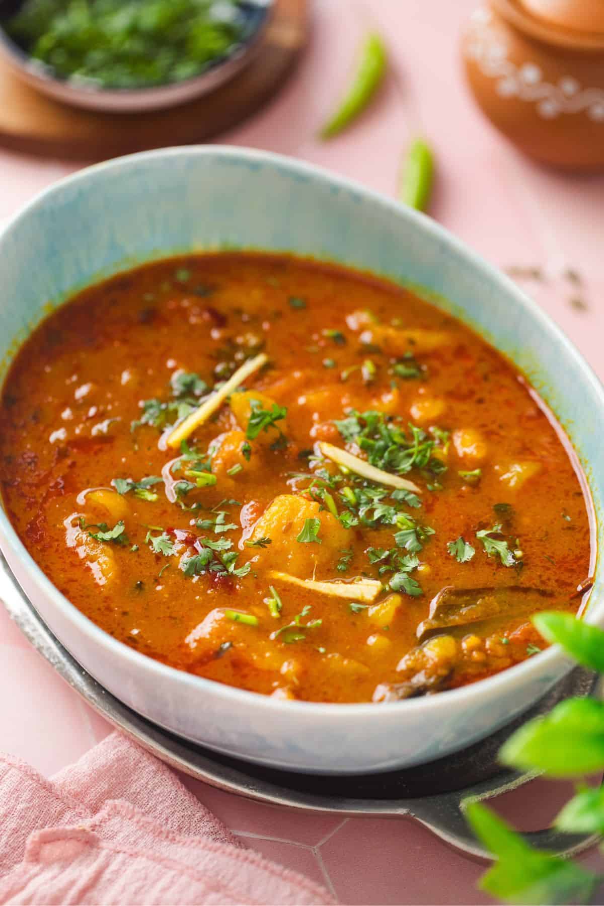 Aloo Sabzi served in an oval blue bowl.