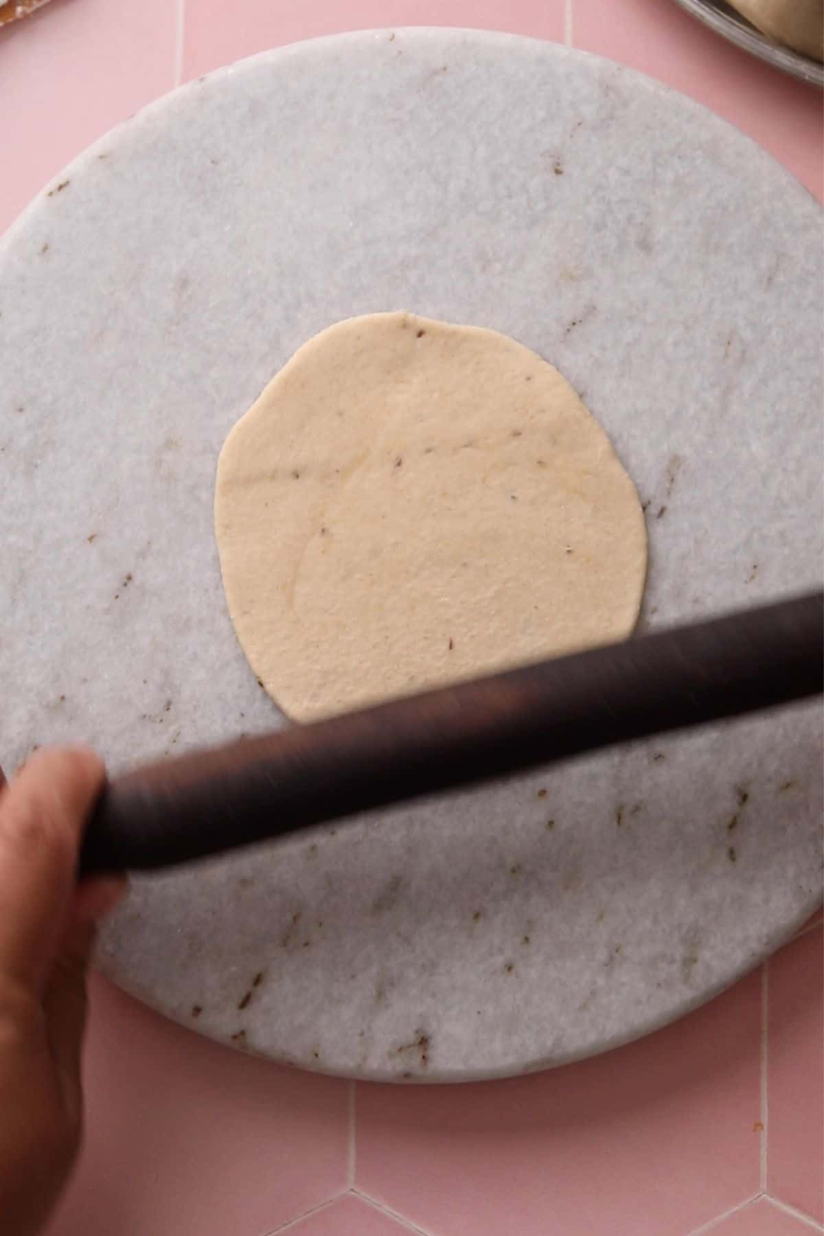 Rolling a poori with a rolling pin.