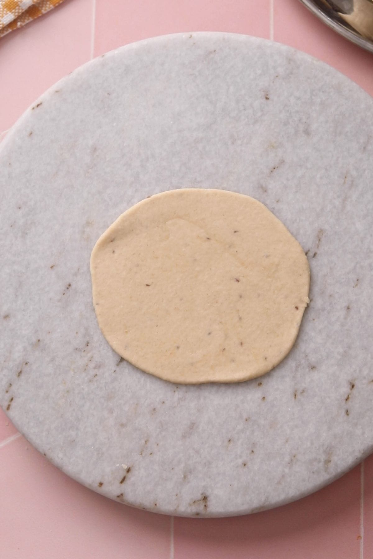 A rolled poori on a marble rolling boa