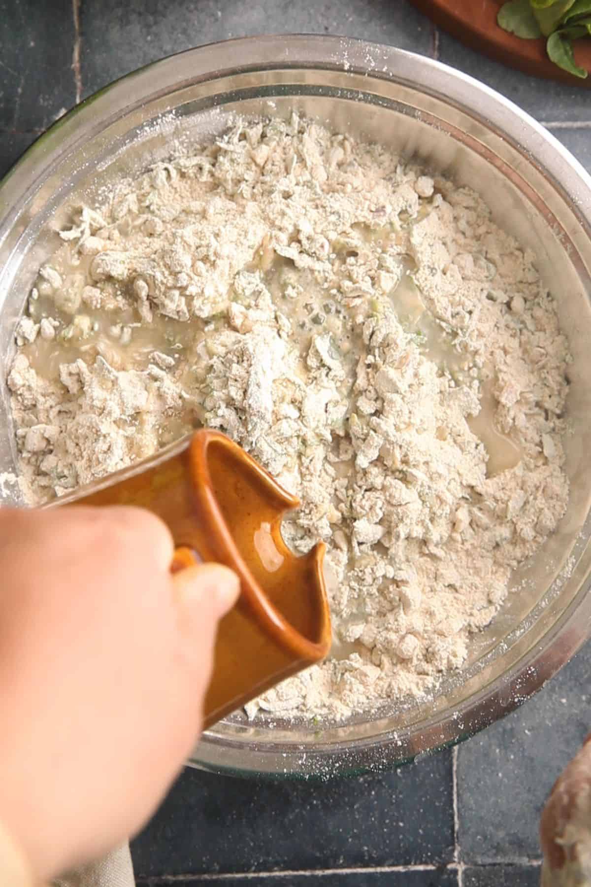 Water is poured on flour to make a dough.