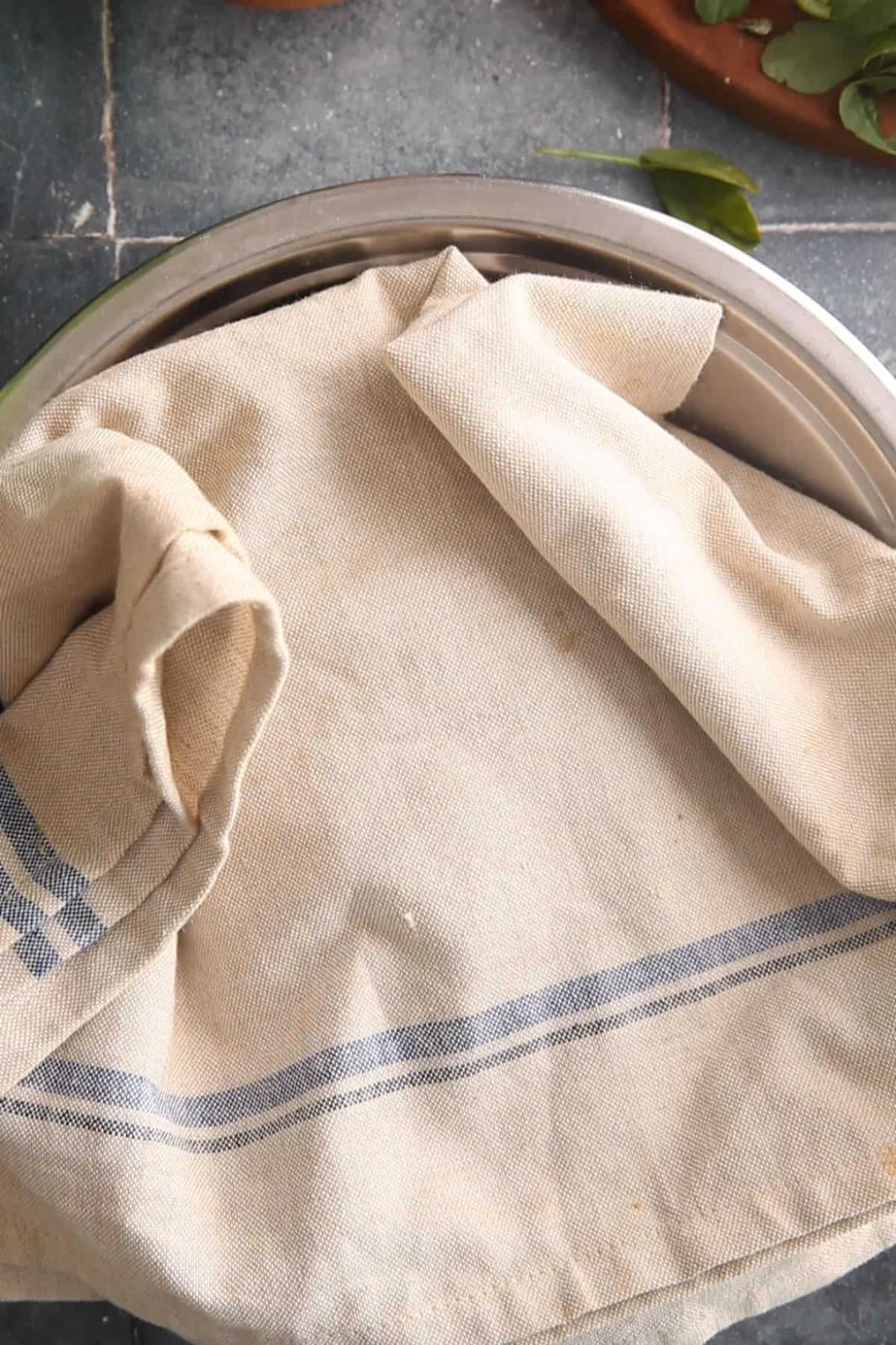 Methi dough is covered with a cloth to rest.