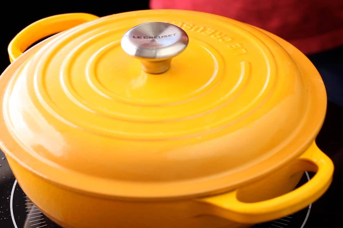 The cooking pot is covered for slow cooking.