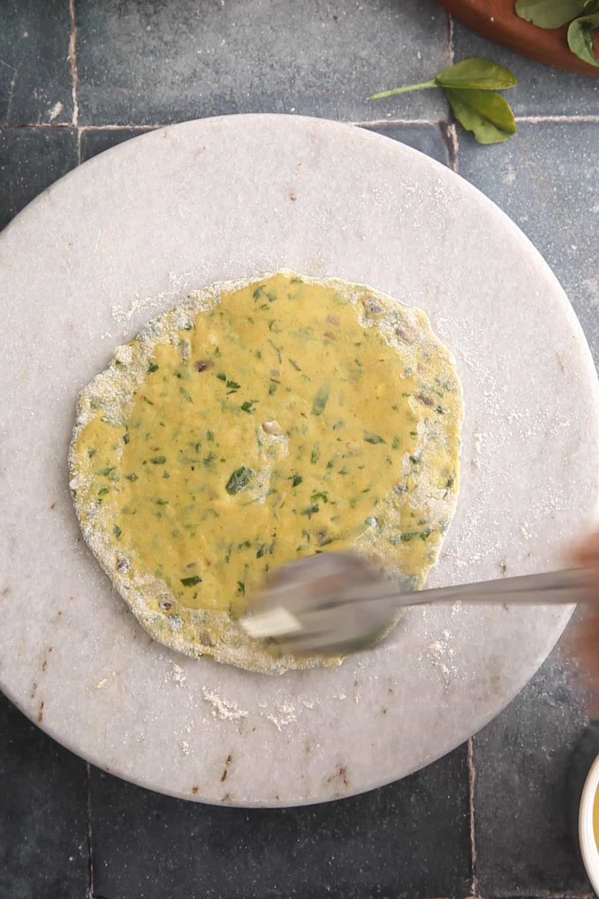 Oil is smeared on the rolled dough.