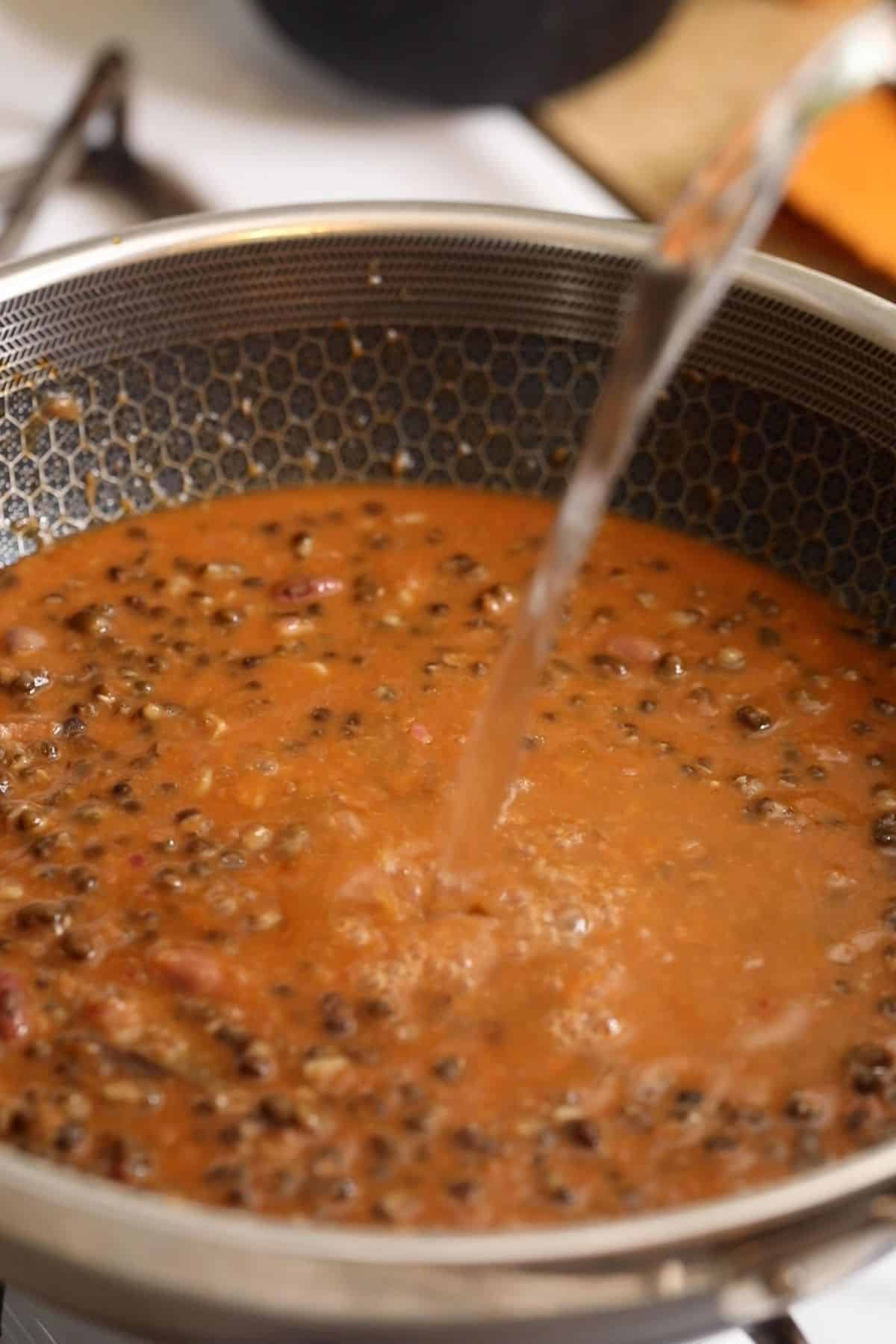 Hot water is being poured over the lentils.