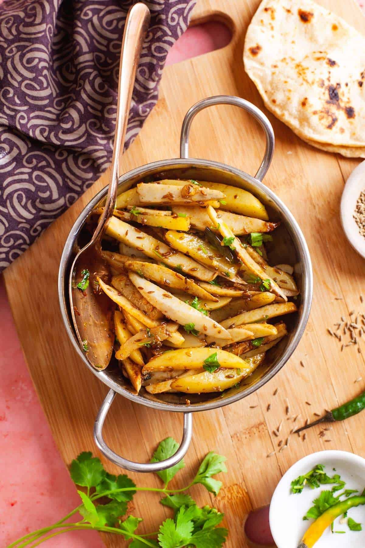 Arbi ki Sabzi served in a small steel kadai (wok)with roti.