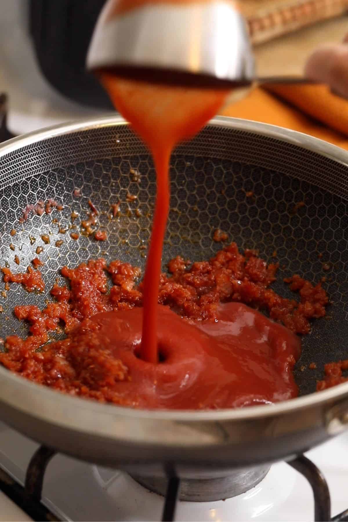 Tomato sauce is poured over the onions.