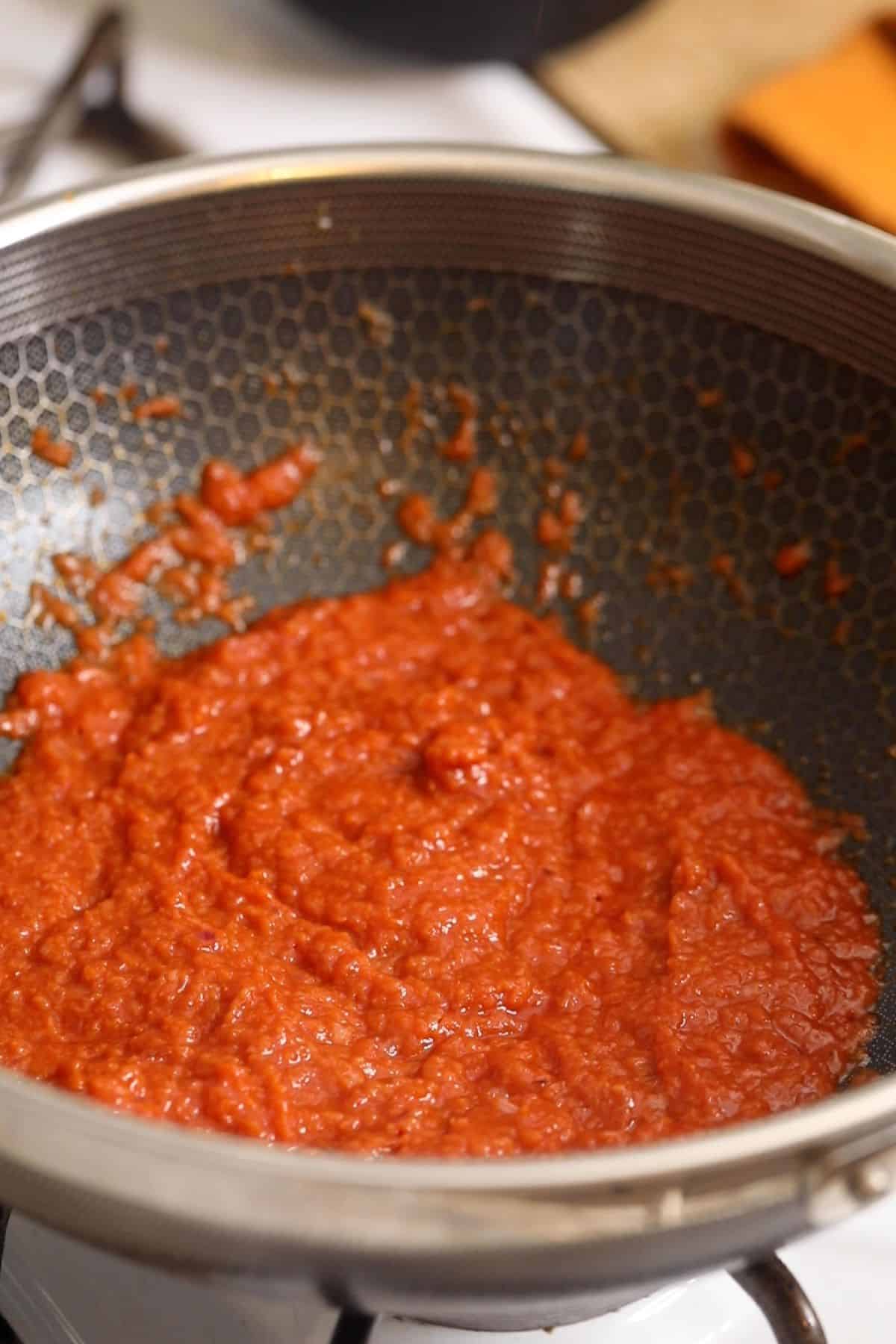 Tomato sauce is cooked until shiny.