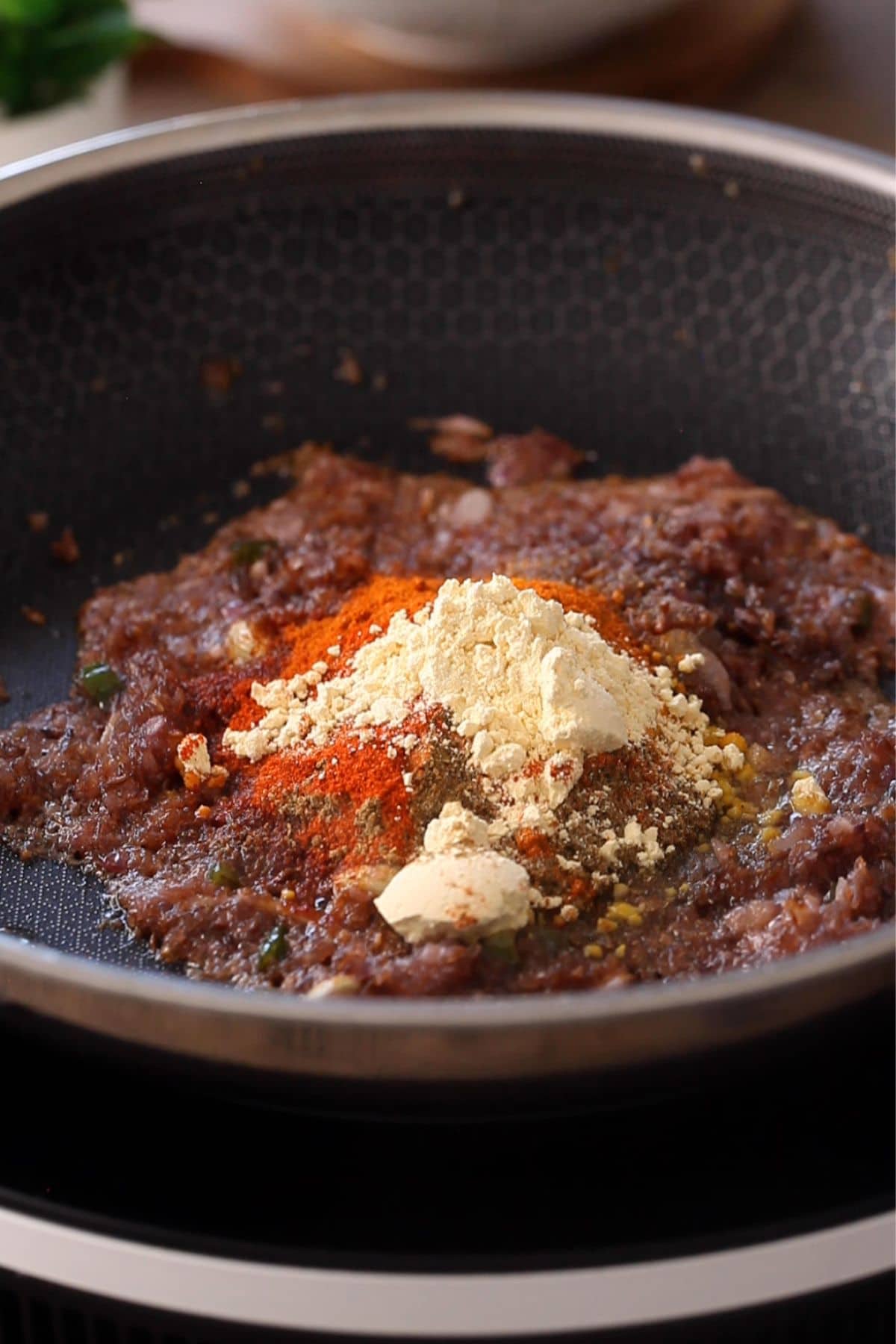 Spice powders and gram flour is added to the browned onions.