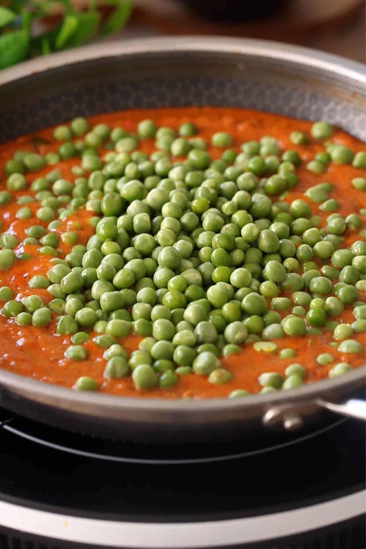 Fresh peas are added to masala. 
