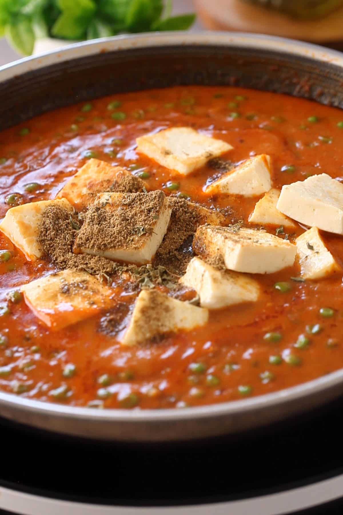 Paneer is added to the peas gravy along with finishing spices. 
