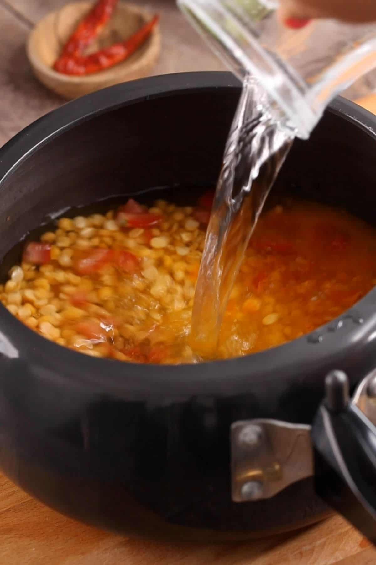 Water is added to pressure cooker.
