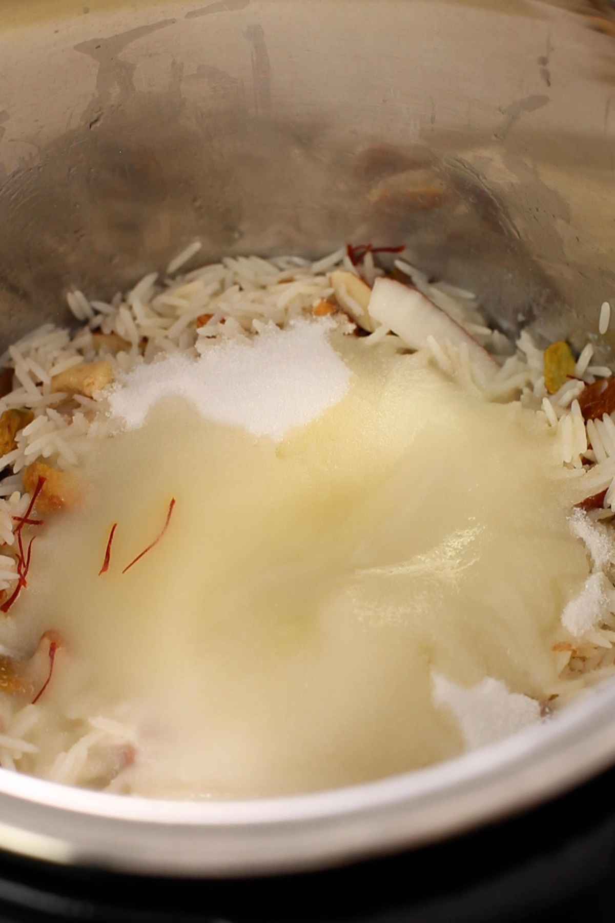 Add sugar and saffron soaked in milk to zarda.