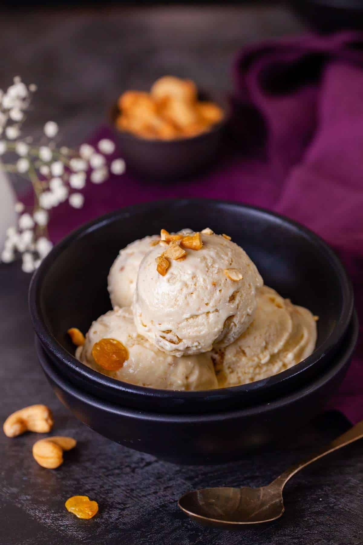 Kaju Kishmish Ice Cream in a black bowl.