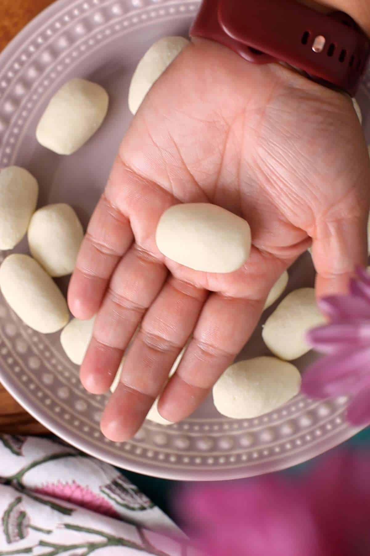 Shaping jamuns in oblong shape.