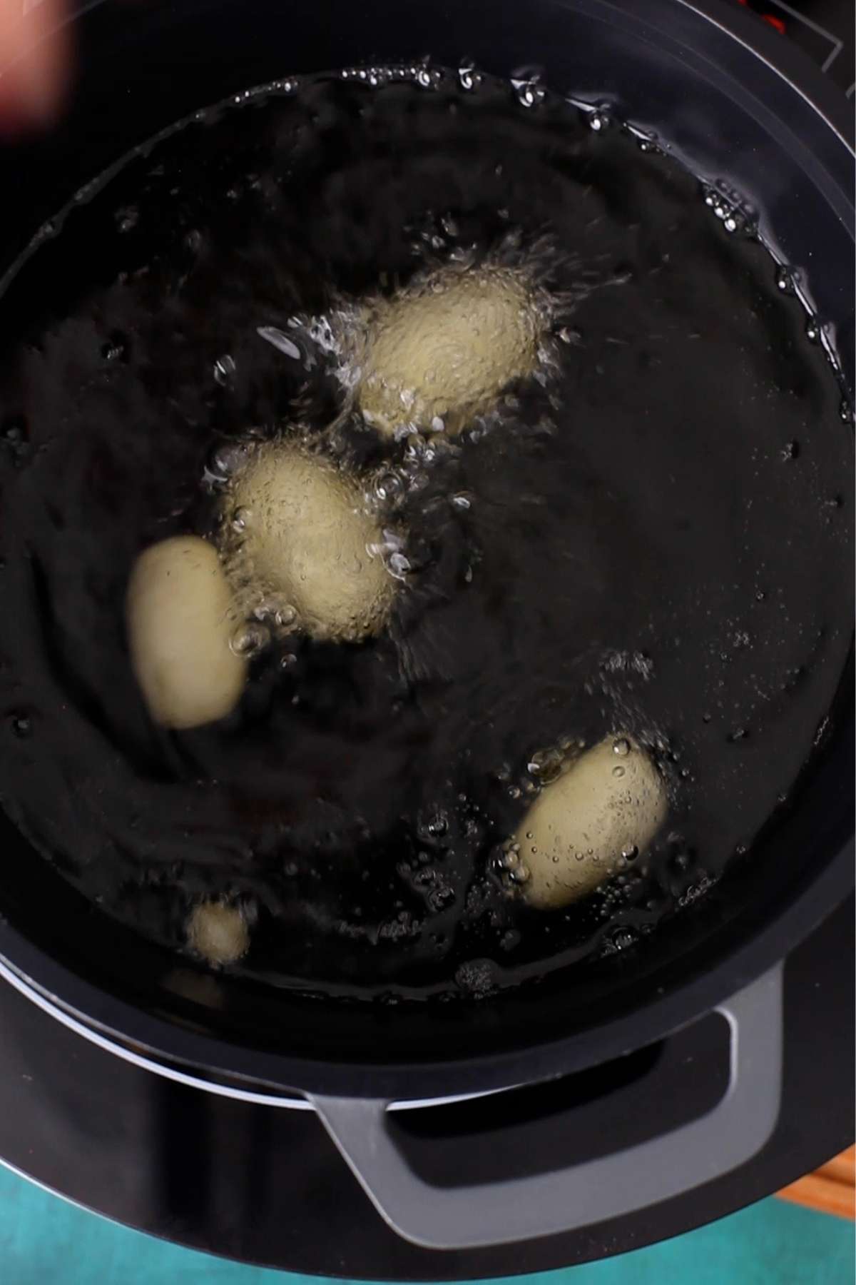 Black Jamuns frying in oil.