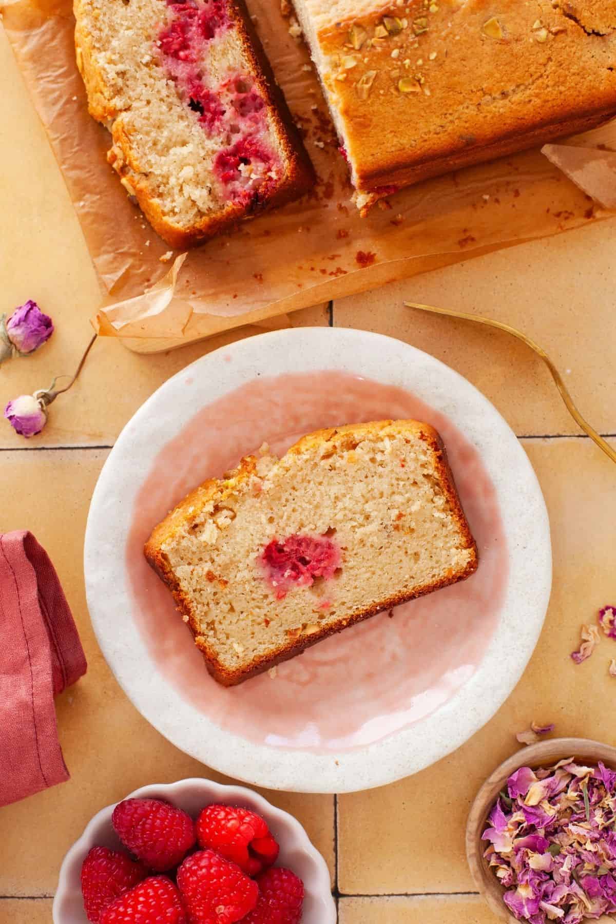 Slice of rose rapsberry cake served on a pink and white plate.