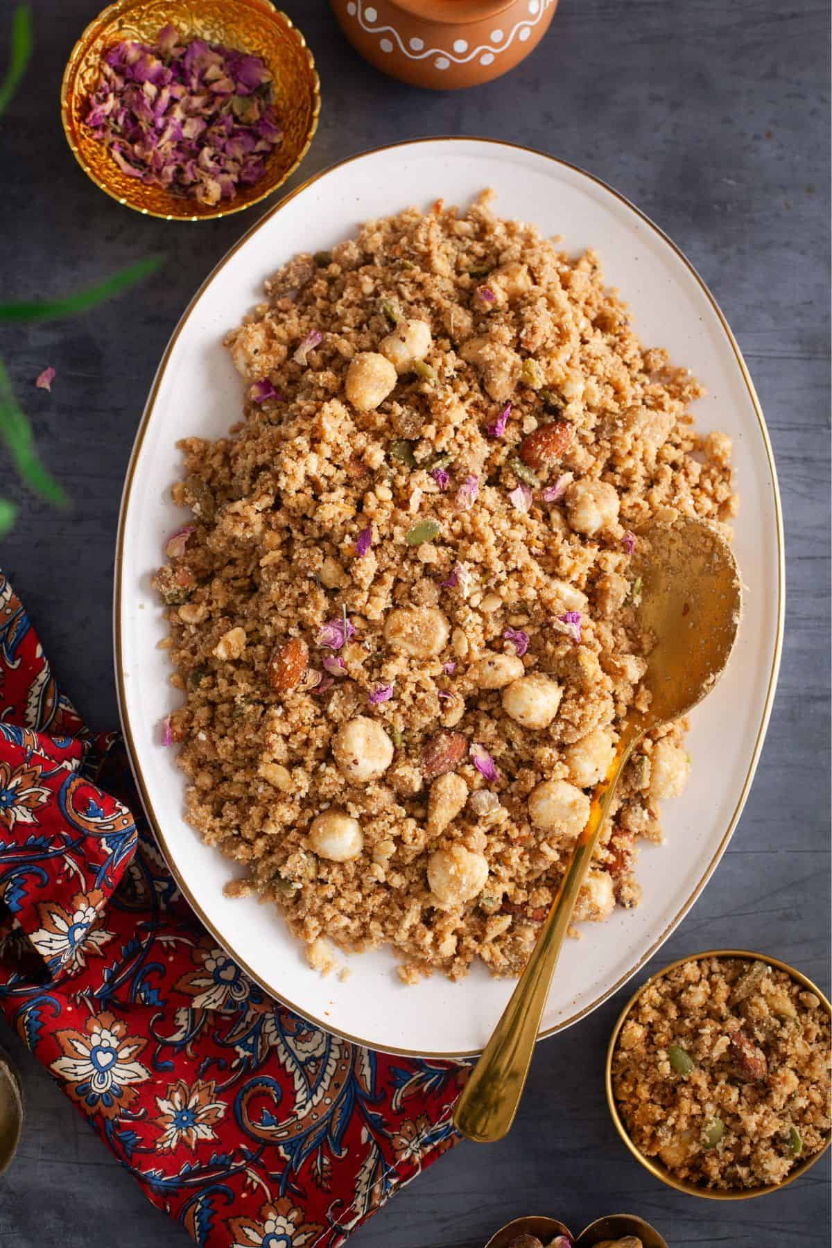 Overhead Image of panjeeri in a large platter scattered with rose petals. 