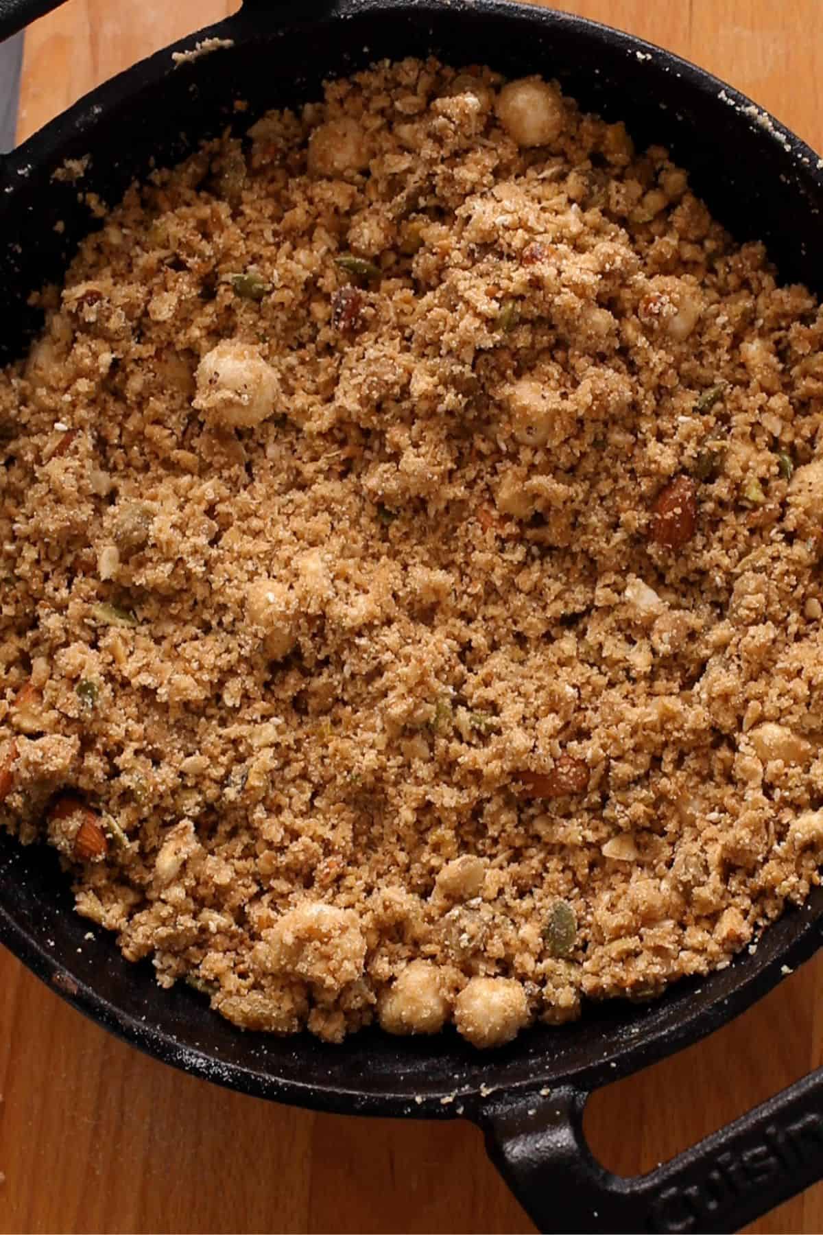 Panjiri is mixed together with hands until it resembles a crumble.