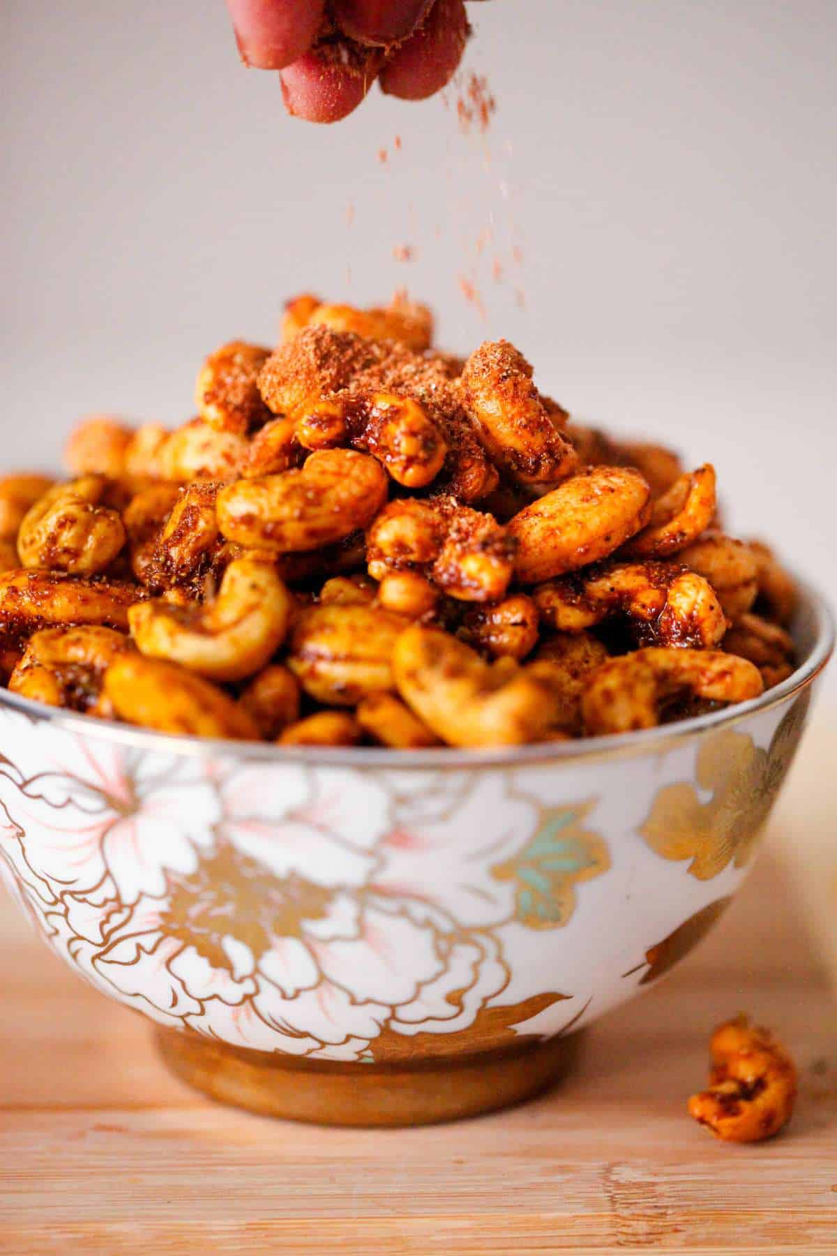 Sprinkling dry masala over kaju.