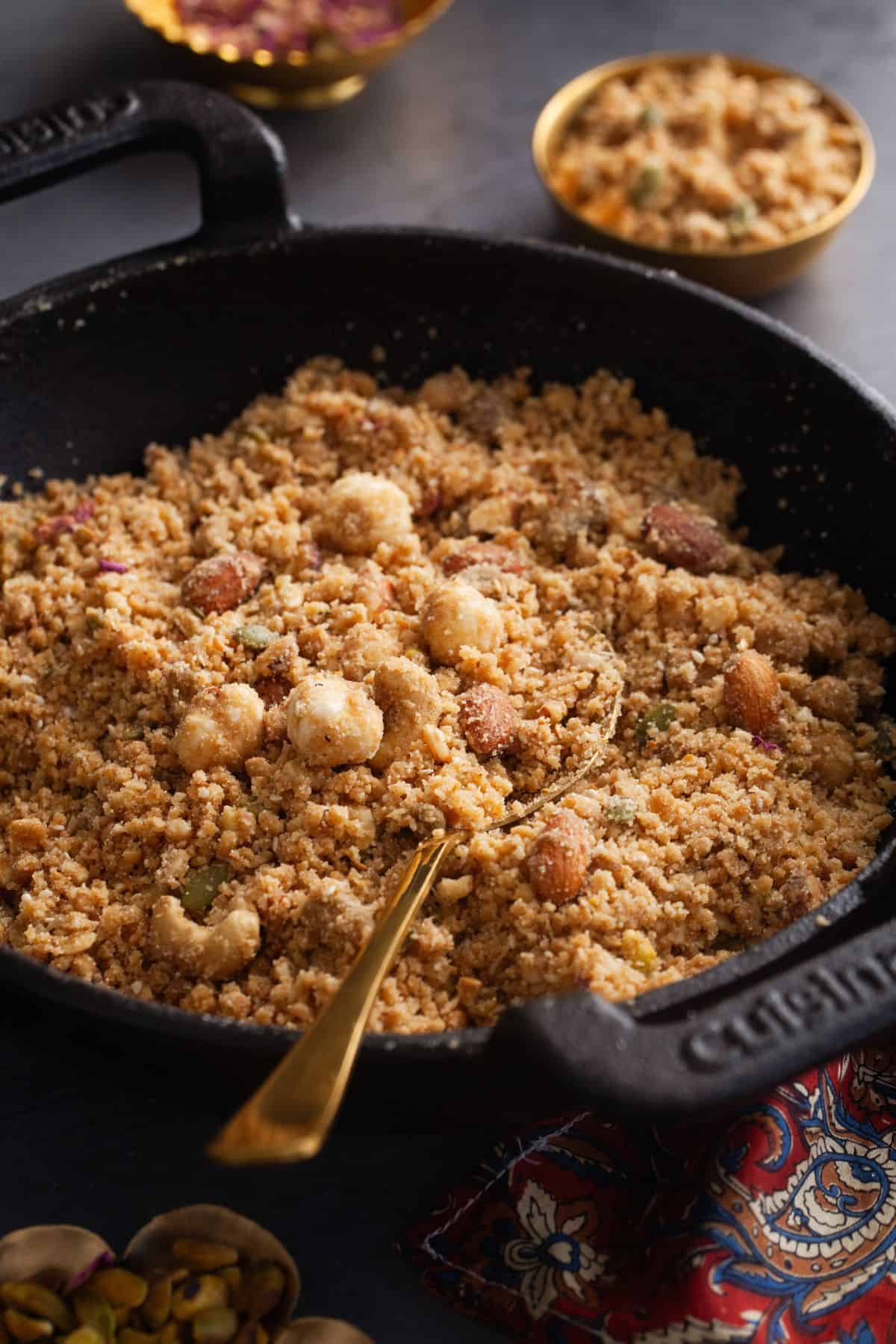Side view of panjeeri in a cast iron kadai. 