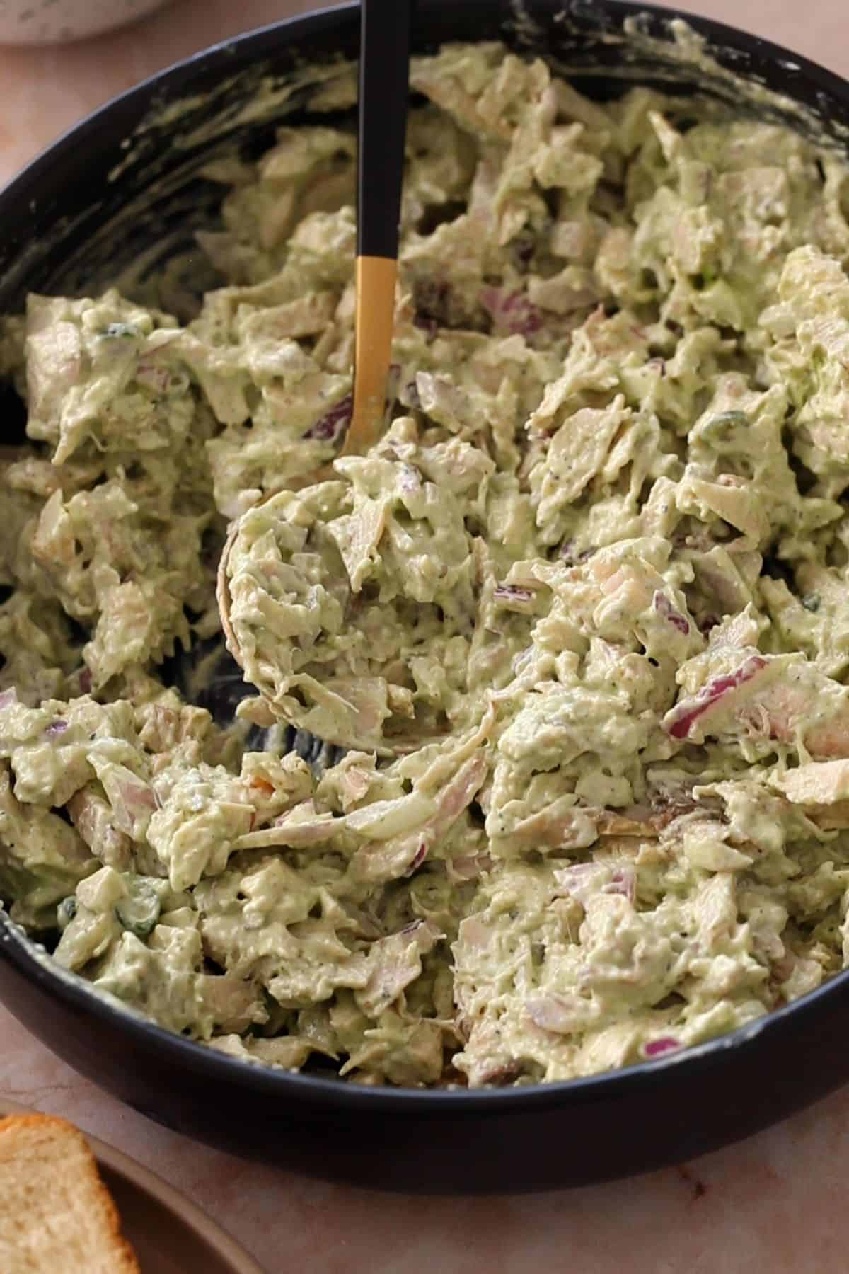 Chicken filling for chutney sandwich in a large black bowl.