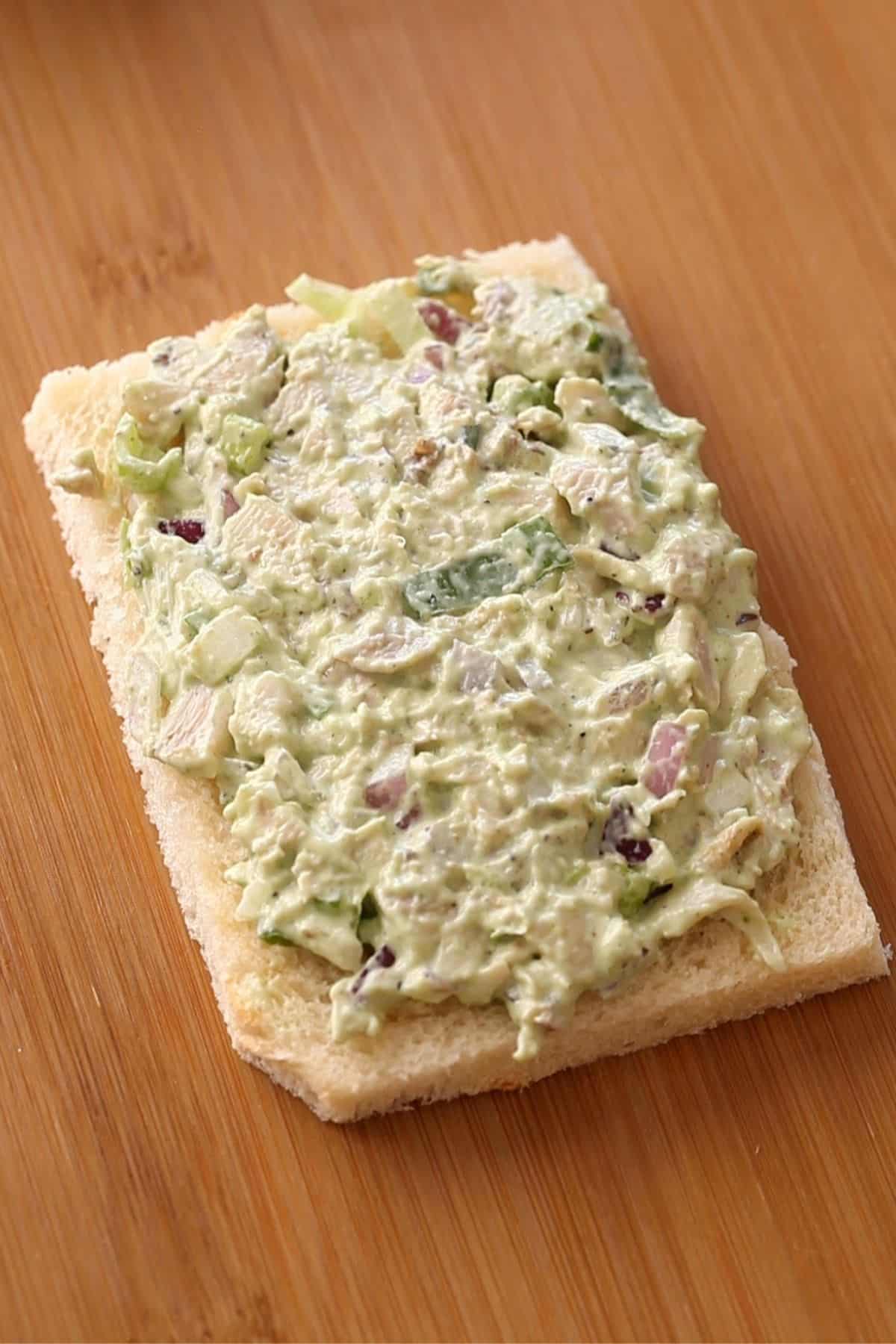 Chicken filling spread on a white bread slice.