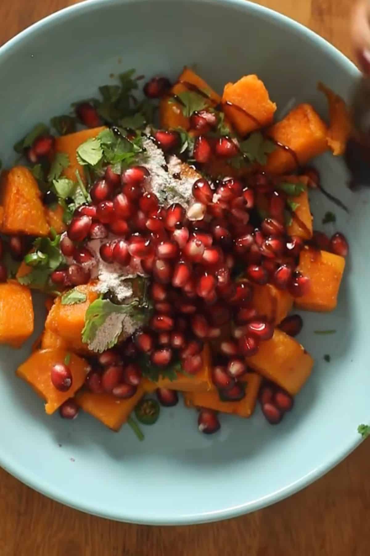Sweet potato is topped with chaat spices, pomegranates, tamarind chutney and cilantro.