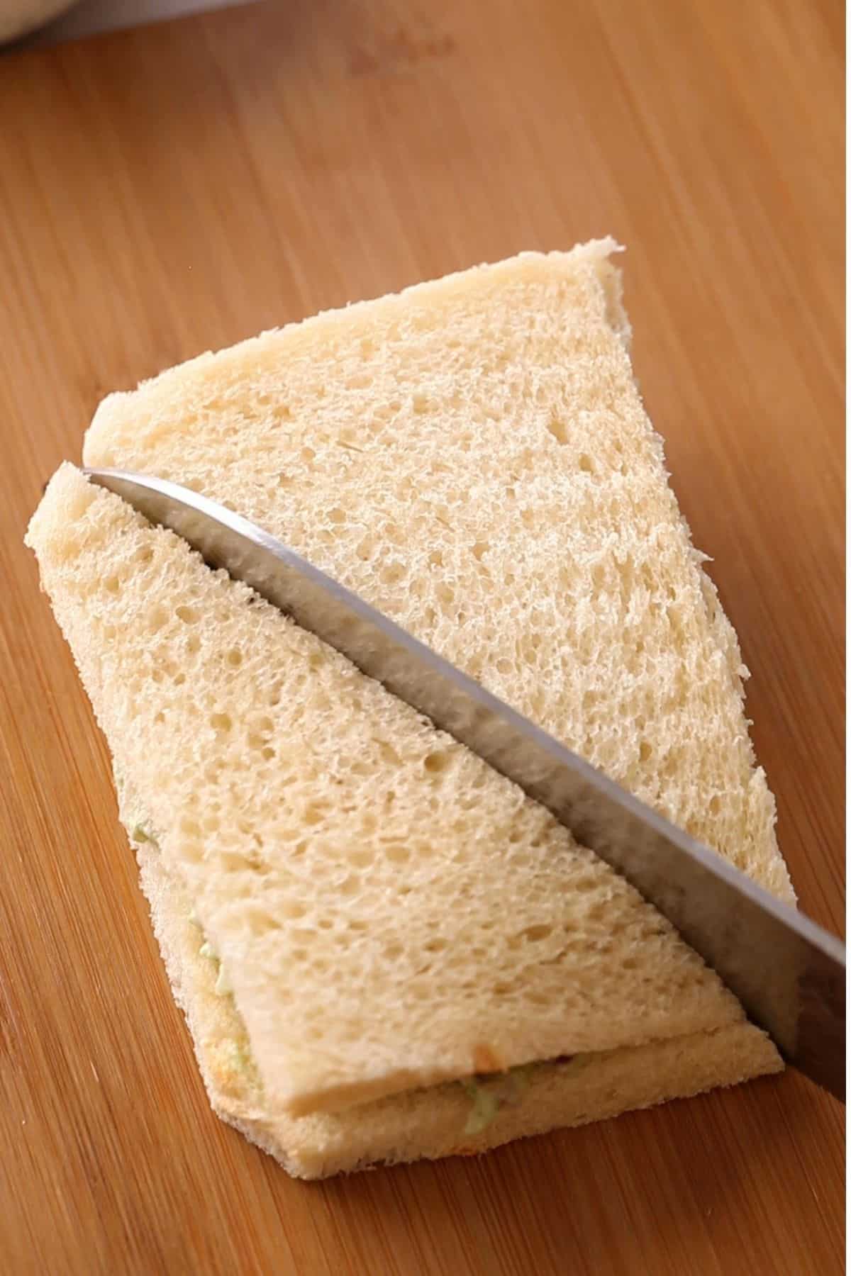 Chutney sandwich sliced into half using a knife.