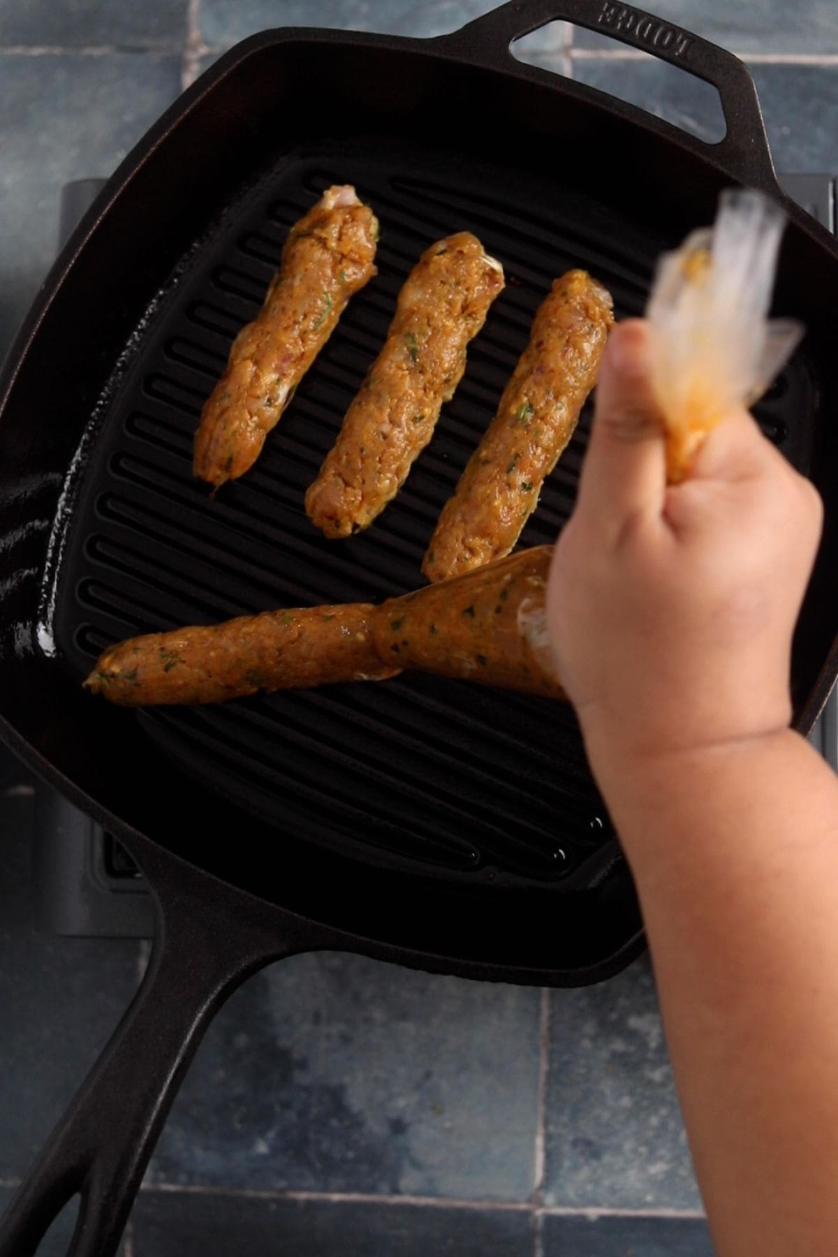 Seekh kebabs are piped on a hot cast iron grill pan.
