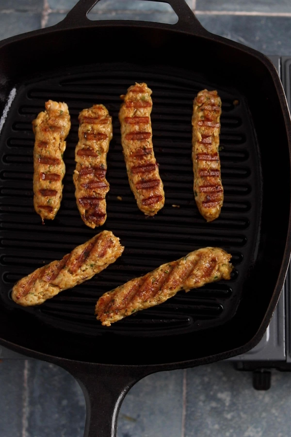 Cooked chicken seekh kebabs have grill marks and are ready to serve.